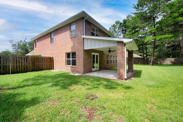 back of property with a patio, a fenced backyard, brick siding, a ceiling fan, and a lawn