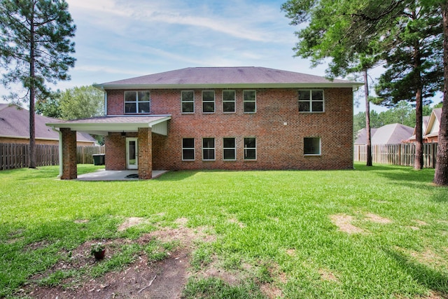 back of house featuring a fenced backyard, a yard, brick siding, and a patio