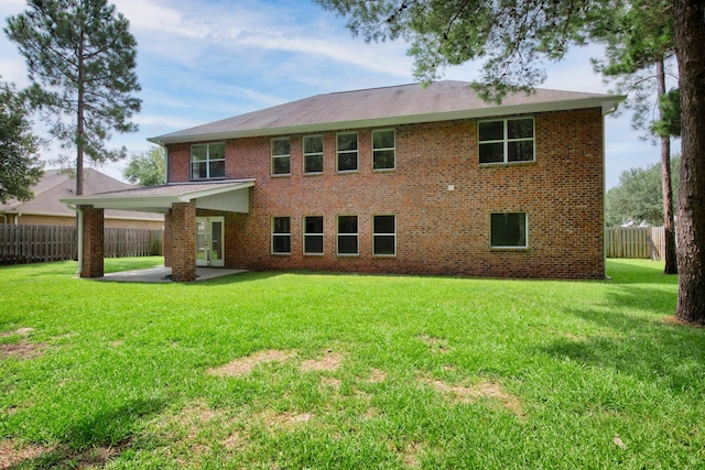 rear view of house with a patio and a lawn