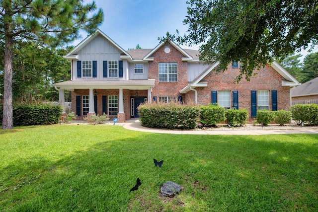 view of front of property with a front lawn, board and batten siding, and brick siding