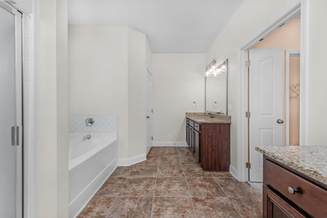 full bathroom with a shower with shower door, baseboards, a bath, and vanity