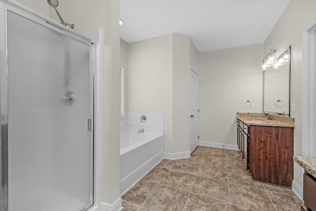 bathroom featuring a bath, a stall shower, vanity, and baseboards