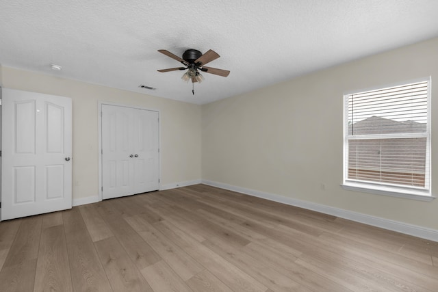 unfurnished bedroom featuring light hardwood / wood-style flooring, a textured ceiling, and ceiling fan