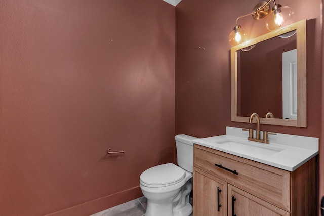 bathroom with toilet, tile patterned flooring, and vanity