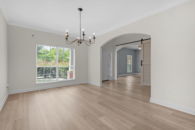 unfurnished room featuring crown molding, a barn door, a chandelier, and light hardwood / wood-style floors