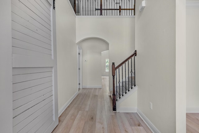 entrance foyer featuring a towering ceiling, a barn door, and light wood-type flooring