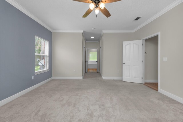 spare room featuring light carpet, ceiling fan, and ornamental molding