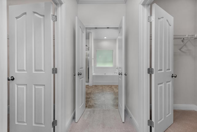 corridor featuring baseboards and light colored carpet