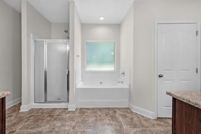 bathroom with a garden tub, a stall shower, and vanity