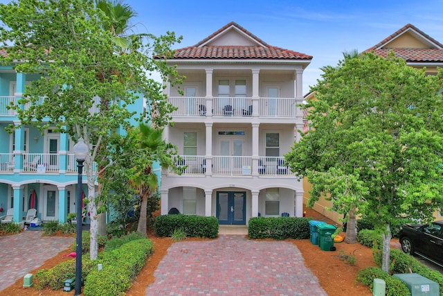 view of front of property featuring a balcony and french doors