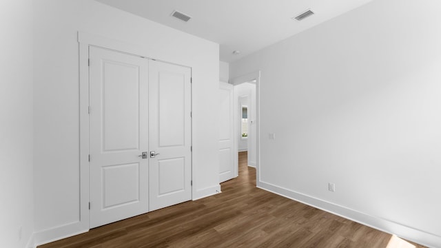 unfurnished bedroom with wood-type flooring and a closet