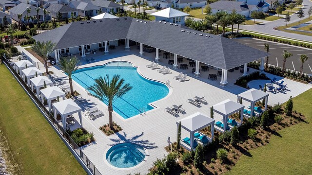 view of pool featuring a community hot tub, a patio, and a yard