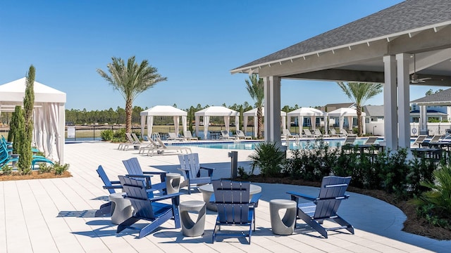 wooden terrace featuring a gazebo, a community pool, and a patio area