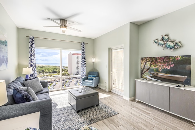 living room featuring ceiling fan, baseboards, and light wood-style floors