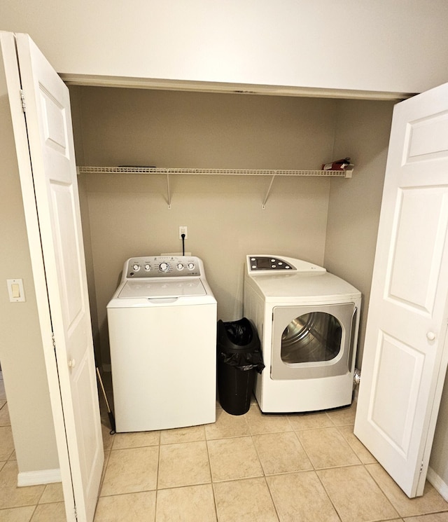 laundry room featuring separate washer and dryer and light tile patterned flooring