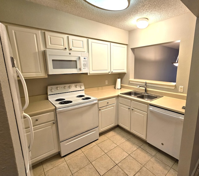 kitchen with white appliances, white cabinets, a textured ceiling, sink, and light tile patterned floors