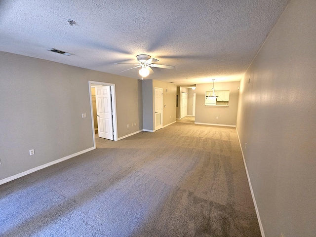 carpeted spare room featuring ceiling fan and a textured ceiling