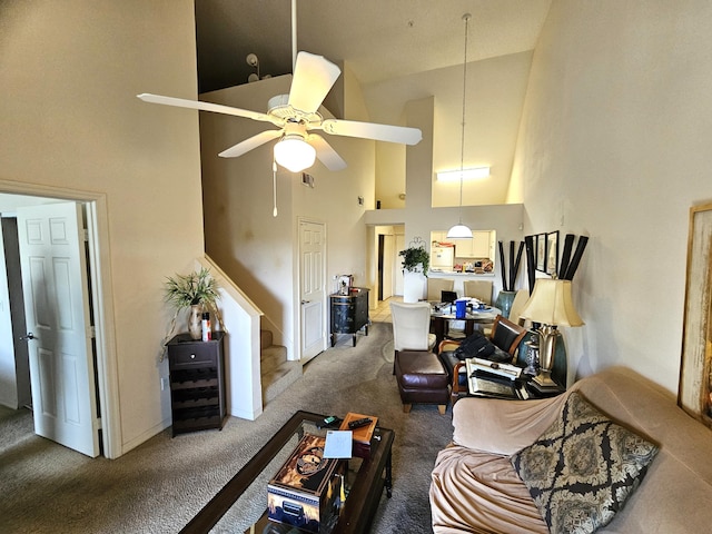 carpeted living room with ceiling fan and high vaulted ceiling