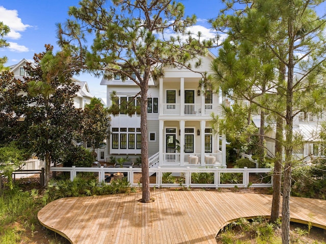 rear view of house with a balcony and covered porch