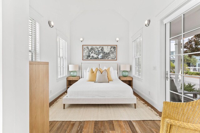 bedroom with wood-type flooring and vaulted ceiling