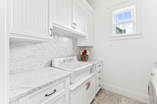 kitchen with light tile patterned flooring, white cabinets, light stone counters, decorative backsplash, and sink