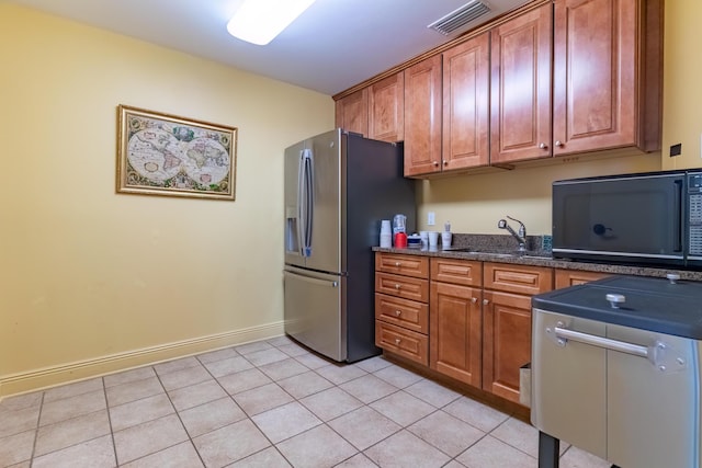 kitchen featuring stainless steel refrigerator with ice dispenser, sink, and light tile patterned flooring