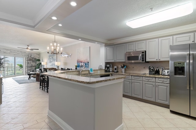 kitchen featuring gray cabinetry, sink, stainless steel appliances, and a center island with sink