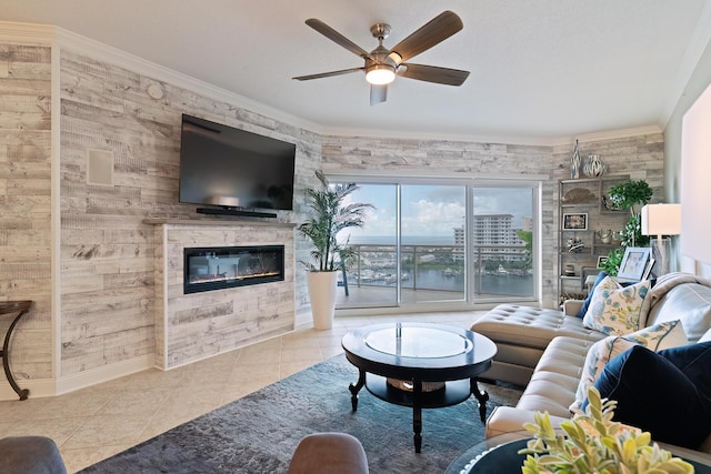 tiled living room with ceiling fan, ornamental molding, and a fireplace