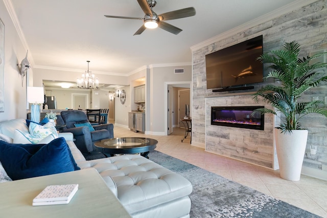 living room with crown molding, a tiled fireplace, ceiling fan with notable chandelier, and light tile patterned floors