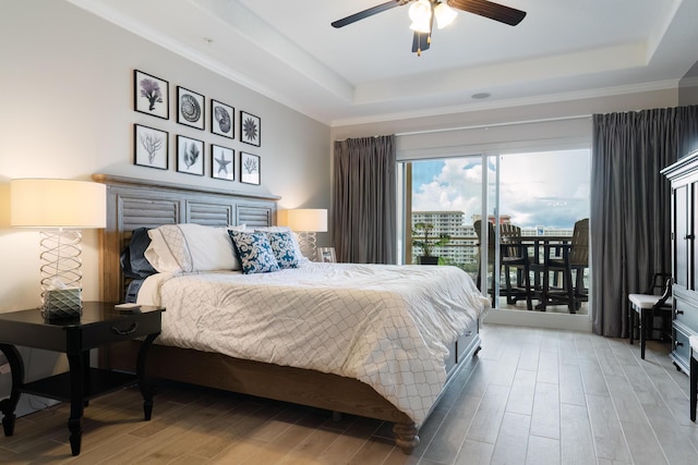 bedroom with a raised ceiling, access to outside, ceiling fan, and light hardwood / wood-style flooring