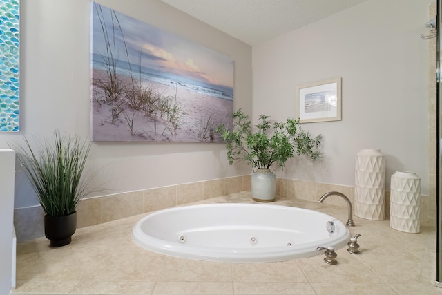 bathroom with tiled bath and a textured ceiling