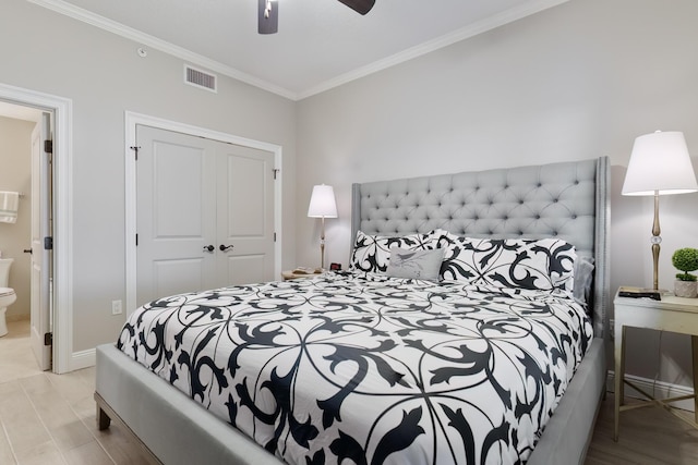 bedroom featuring ensuite bath, light wood-type flooring, ornamental molding, a closet, and ceiling fan