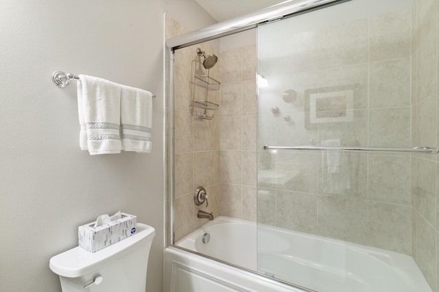 bathroom featuring toilet and combined bath / shower with glass door