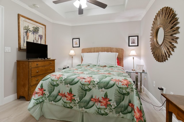 bedroom with a raised ceiling, crown molding, ceiling fan, and light hardwood / wood-style floors