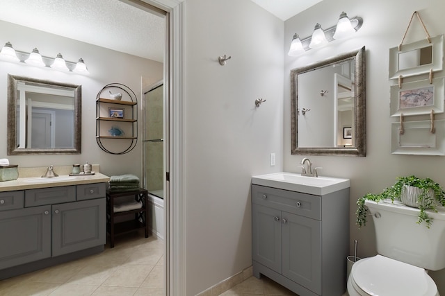 full bathroom with enclosed tub / shower combo, tile patterned floors, toilet, and vanity