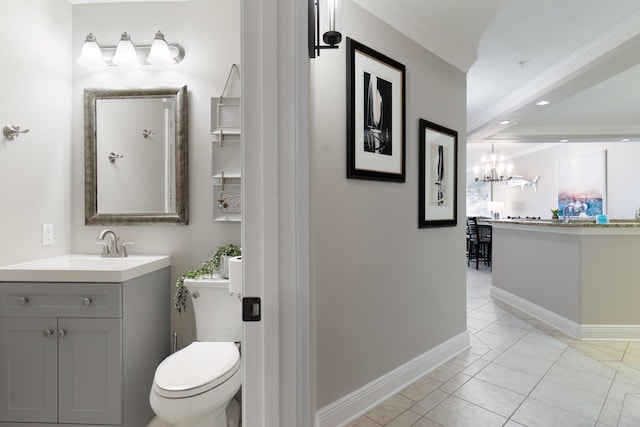 bathroom with toilet, crown molding, vanity, a notable chandelier, and tile patterned flooring