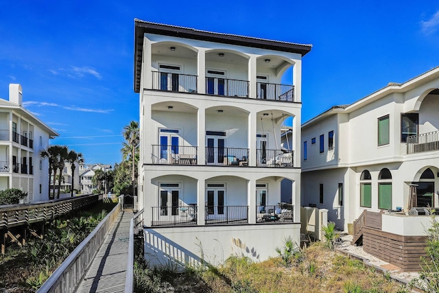 rear view of property with a balcony and french doors