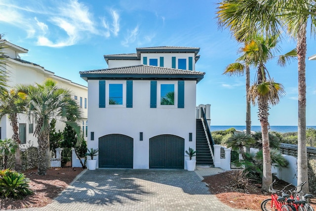 mediterranean / spanish-style home with a water view and a garage