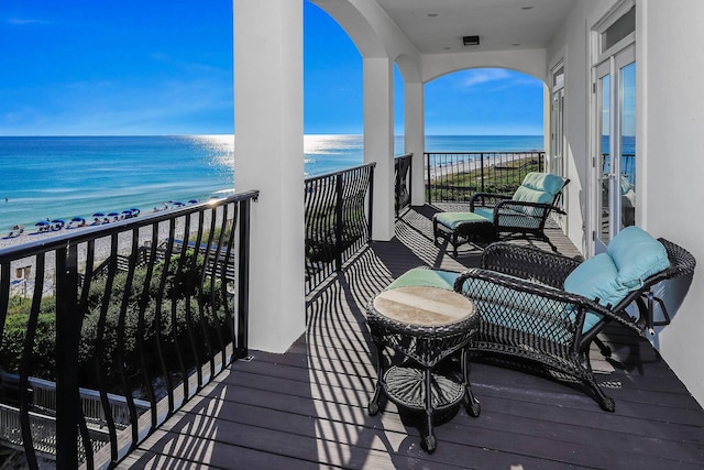 balcony featuring a water view and a beach view