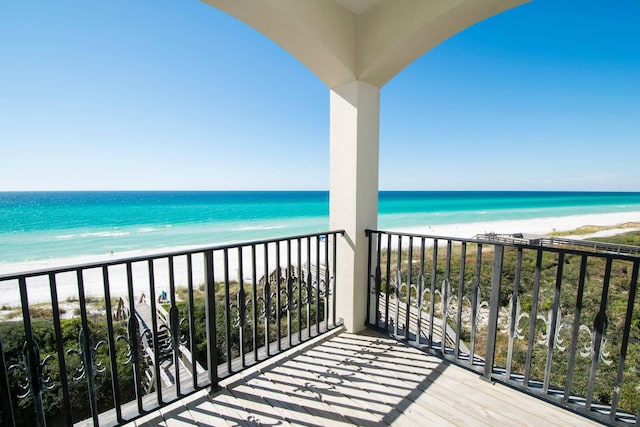 balcony featuring a beach view and a water view