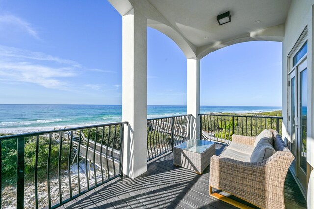 balcony featuring a water view and a view of the beach