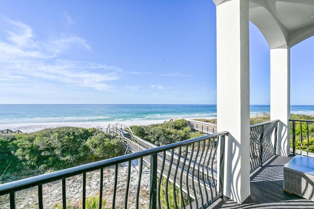 balcony featuring a view of the beach and a water view