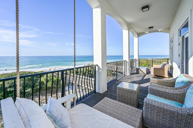 balcony featuring a water view, outdoor lounge area, and a view of the beach