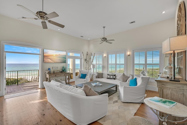 living room featuring a wealth of natural light, light hardwood / wood-style floors, and ceiling fan