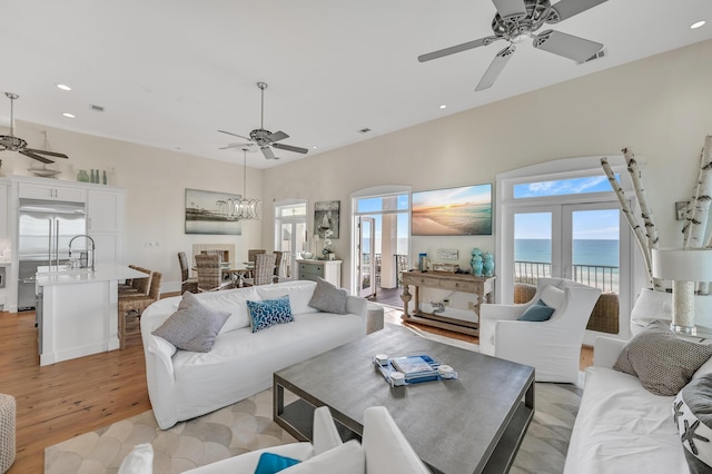 living room featuring plenty of natural light, light hardwood / wood-style floors, and ceiling fan