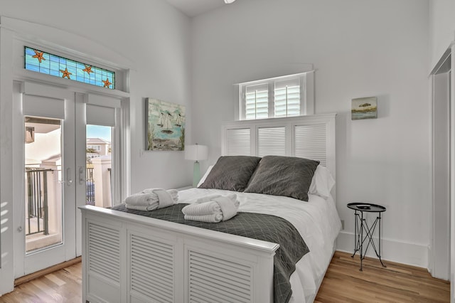 bedroom with multiple windows, access to exterior, and light hardwood / wood-style flooring