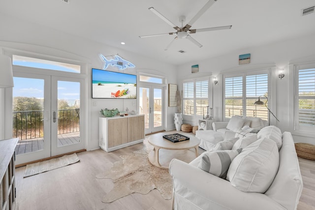 living room with french doors, ceiling fan, and light wood-type flooring