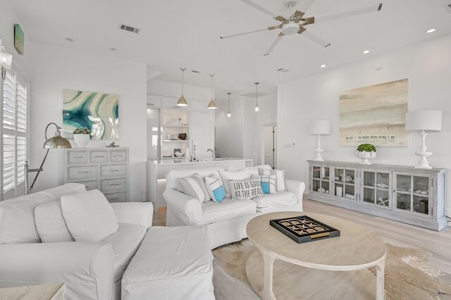 living room featuring ceiling fan and light hardwood / wood-style floors