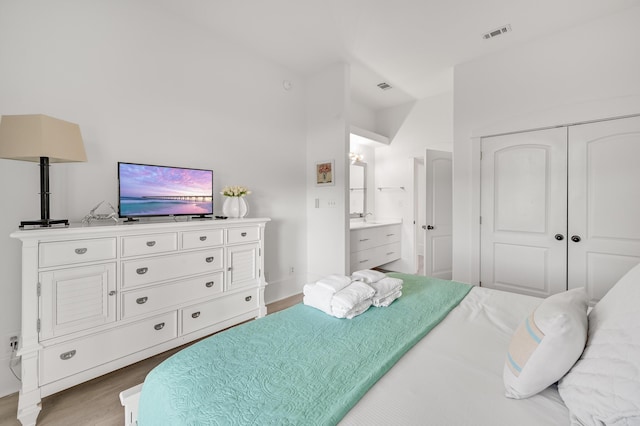 bedroom featuring hardwood / wood-style floors, connected bathroom, and a closet