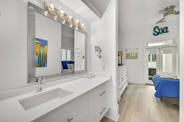 bathroom with vanity, hardwood / wood-style floors, and french doors